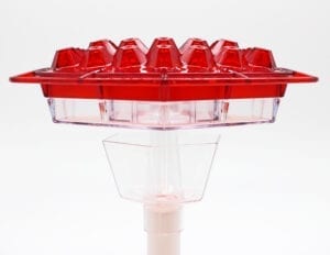 A red plastic container sitting on top of a white stand.